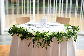 Crisp White Lily And Greenery Garland Sweetheart Table Decor At The Bk Botanical Garden Atrium Moder Lily Centerpieces Sweetheart Table Decor Greenery Garland