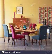 Download This Stock Image Pink Turquoise And Blue Velour Upholstered Dining Chairs At Table In Mo Dining Room Colors Colored Dining Chairs Yellow Dining Room