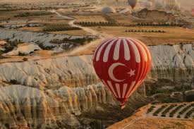 Kolorowe balony na gorące powietrze nad zaśnieżonym krajobrazem czerwonej doliny z bajkowymi kominami o wschodzie słońca w sezonie zimowym w kapadocji, turcja 00:20 widok z lotu ptaka kapadocja, turcja: Lot Balonem W Kapadocji Czy Warto Balkany Wedlug Rudej