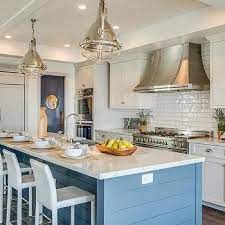 An island makes a stately focal point in any kitchen. Blue Shiplap Kitchen Island With Sleek White Leather Counter Stools Cottage Kitchen Kitchen Design New Kitchen Cabinets Shiplap Kitchen