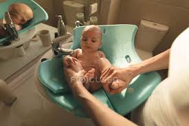 The bath seat can be used on a counter, in a sink or in a typical bath tub. Mother Washing A Baby In Baby Bath Seat In Bathroom Sink At Home Real Life Apartment Stock Photo 208531896