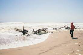 Shawnee ship that was wrecked on the skeleton coast of namibia, south west africa. Young Man Walking Next To Remains Of A Shipwreck On A Beach Skeleton Coast Namibia By Alejandro Moreno De Carlos
