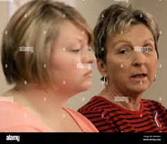 Karen Seckinger, right, mother of burn victim Paul Seckinger, looks over at  Jenny Purnell as she talks to the media about her son and Mrs. Purnell's  husband as they face a long