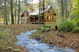 A log cabin interior is generally characterized by warm furnishings like a fireplace, natural materials for a rustic design, statement lighting fixtures for the aesthetic appeal, wood features throughout for charm and texture, and cozy furniture for comfort and warmth. Rustic Retreat Log Cabin In The Woods Tiny House Blog
