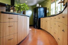 Stainless steel countertops and appliances make a crisp, industrial contrast against the rich wood finish. Cost Of Kitchen Cabinets Examples