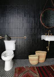 This traditional styled bathroom glossy black floor tiles, with black subway tiles halfway up, with white all the way to the blackened bronze fixtures help this shower to feel integrated into the space. Tribal Black Bathroom Kohler Ideas