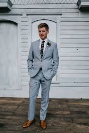 When accessorizing your grey suits with tie bars, lapel pins or cufflinks, try sticking to metallic silver or white hues for a polished look. A Light Grey Suit A White Shirt A Moody Floral Tie And Amber Shoes For A Dapper Look Light Grey Suits Light Grey Suit Brown Shoes Grey Suit Brown Shoes