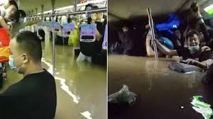 People wade through floodwaters along a street following heavy rains in zhengzhou, in china's central henan province, on july 20. 8eeh0wn8zkz6bm