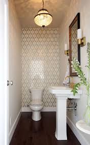 The geometric side table and patterned wallpaper represent the new, while the retro faucets and brass mirror keep their roots in the past. 40 Powder Room Ideas To Jazz Up Your Half Bath