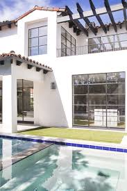 Black And White Spanish Style Home Exterior White Facade Spanish Tile Black Windows Wood Slats Pergola Simple Black Railing For The Top Decks Spanish Exterior Railings Outdoor Spanish Modern