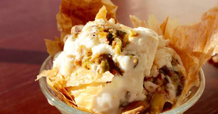 Modern plated presentation of baklava recipe with ice cream and drizzle of honey on a restaurant plate