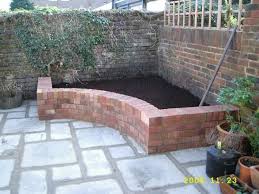 Raised Brick Garden Bed Tucks Away In A Corner The Curve Is Pleasing To The Eye And Makes It Easier To Reach Pla Brick Garden Brick Planter Corner Flower Bed
