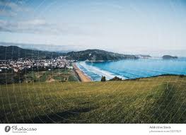 Relative chiefly to picturesque beauty; Picturesque View From Green Hill Of Seashore And Town On Sunny Day In Spain A Royalty Free Stock Photo From Photocase