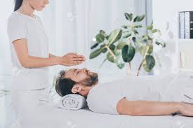 Side View Of Calm Bearded Man With Closed Eyes Receiving Reiki Treatment On Massage Table Stock Photo, Picture And Royalty Free Image. Image 117858019.