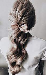 Long Blonde Balayage Hair Curls Into A Pink Ribbon Tie Best Bridal Shower Hair Ideas Baby Shower Hair Styles Long Hair Styles Prom Hairstyles For Long Hair