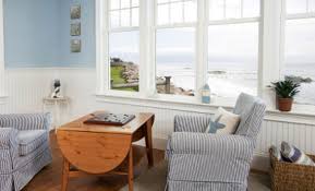 Soggiorno di una casa al mare con un divano e un tavolo con sedie. Arredare La Casa Al Mare Idee E Consigli Per Una Casa Fresca E Chic Leitv