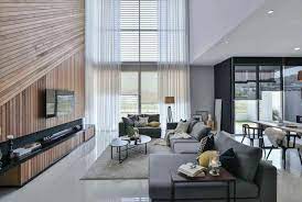 Accent lighting, the wall panelling in the niches and the wooden ceiling bring warmth to the room. Wil S 11 Residence Living Room With A Double Volume Wood Wall Feature Matched With Sheer Curtains Caandesign Architecture And Home Design Blog