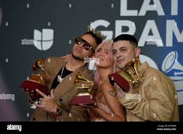 Singers Obi no the droo, Karol G and Santiago Alvarado, pose with the 3  Grammys they have been awarded during the Latin Grammy 2023 awards gala, at  the Palacio de Congresos de