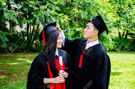 Find great deals on graduation gown in phoenix, az on offerup. A Man And Woman Couple Dressed In Black Graduation Gown Or Graduates With Congratulations With Graduation Hats Is Standing Smiling And Holding Hat With The Park Background Stock Photo Picture And Royalty
