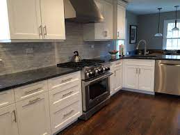 The backsplash is white subway tile that is laid corner to corner. Counters Are Polished Steel Gray Granite Backsplash Is Carrara Random Tile Honed White White Granite Countertops Kitchen Remodel Grey Granite Countertops