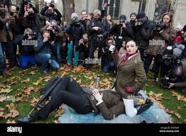 London, UK. 12 December 2014. A couple demonstrates face-sitting with many  photographers taking pictures. Protest against new censorship legislation  banning various sex acts from online porn videos filmed in the UK in