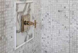 Porcelain showers with marble chair railings on walls. White Marble Tiles With Gold Trim Novocom Top