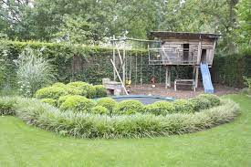 leeftuin met een trampoline omringd door struiken tuinplantenbakken tuin achtertuin makeover