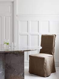 beautifully simple dining area featuring a grey marble table and linen slipcovered chair we love the popular ikea henriksdal chair for its versatility seen h