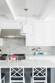 Light Gray Backsplash Tiles Accent White Shaker Cabinets Flanking A Stainless S Kitchen Backsplash Designs Backsplash For White Cabinets Kitchen Cabinets Decor