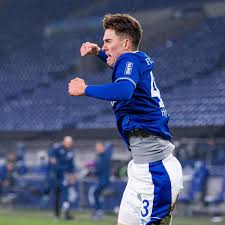 Schalke's matthew hoppe scores his third goal against hoffenheim and goalkeeper oliver baumann in gelsenkirchen, germany. L5fsy76ntwmplm