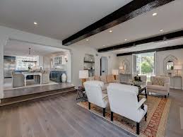 Radial beam patterns give a room the illusion of being round and bring attention to the light fixture in the center of the exposed ceiling supports give an industrial look to a living room. Tan And Orange Sunken Living Room Design Mediterranean Living Room
