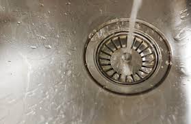 water falling on a steel sink plug hole