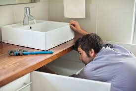 Kitchen sink, food grinder, and dishwasher can discharge through a single 1.5 trap. Plumber Working Under Kitchen Sink Stockphoto
