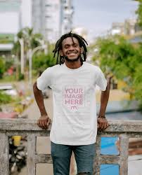 Download T Shirt Mockup With Smiling Black Man Leaning To A Stone Fence Mediamodifier