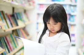 Ilustrasi gambar yang memperlihatkan anak kecil duduk membaca diatas tumpukan buku. Buat Buah Hati Agar Senang Membaca Dengan 10 Buku Cerita Anak Ini Yuk