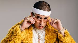 Logo wallpaper illustration bad bunny. Bad Bunny Aesthetic Is Wearing Yellow Dress In Ash Background Wearing Gold Chains Holding Specs With Hands Hd Music Wallpapers Hd Wallpapers Id 42700