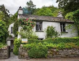 On The Edge Of Grasmere This Tiny Creeper Clad Cottage Formerly A Pub Called The Dove Olive Bough Was Famously Inhabited Cottage Lake District Landscape