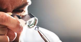 Collection of gold jewelry including rings, chains, and coins spread on surface