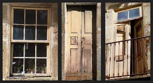 An old fashioned, rustic style black front door on this red brick home is framed in concrete tones, with a simple arched transom window overhead. Designing Old Doors And Windows As Rolhas