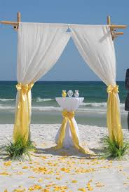 A few bright yellow sunflowers will add color and whimsy to a cascading bouquet of white roses, smilax, blue thistle, and eucalyptus. Shine Like The Sun Yellow Themed Beach Wedding Ideas Beach Wedding Tips