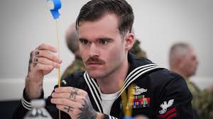 Chaplain Erik Hunt, and Retail Services Specialist Second Class Maicon  Mariano, both assigned to the Whidbey Island-class dock landing ship USS  Rushmore (LSD-47) pet a dog during the Canine Good Citizen visit