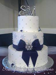 Elegant White Butter Cream Winter Wedding Cake With Snowflakes And Purple Ribbon And Bow Winter Wedding Cake Winter Wonderland Wedding Cakes Wedding Cakes Blue