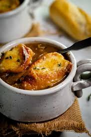 Two Slices Of Baguette With Melted Cheese In A Bowl Of French Onion Soup And Thyme On Top Onion Soup Recipes French Onion Soup Recipe