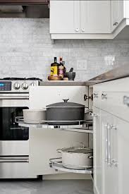 Off White Kitchen Cabinets Fitted With Polished Nickel Pulls And A Gray Quartz Countertop Transitional Kitchen Design Off White Kitchen Cabinets Kitchen Tops