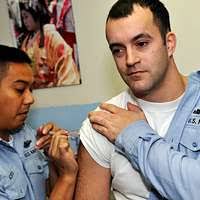 Hospital Corpsman 2nd Class Eric Pacheco administers the H1N1 flu vaccine  to Interior Communications Electrician 2nd Class Stuart Ringrose.