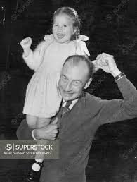 Conductor Relaxes. Joseph Post associate conductor of the Sydney Symphony  Orchestra, gives three-year-old daughter Nola a ride