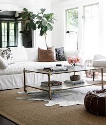 Black And White Rug Living Room Ideas A Black And White Cowhide Rug Is Layered Atop A Bound Sisal Rug In This Stunning Living Room Fe Farm House Living Room Rugs In Living Room Farmhouse Sofa Table