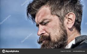 Med stil. Brutal, kaukasisk hipster med bart. En skjeggete mann. Moden  hipster med skjegg. Fremtidig suksess. Mannlig mote. Forretningsmann mot  himmelen. Får hår til å se magisk ut. kopieringsareal