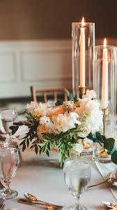 Candles and candle holders make wonderful additions to your reception tables. Reception Table Centerpiece Includes An Elegant Trio Of Brass Candlesticks With Taper Candles Wedding Tall Candles Wedding Hurricane Candle Centerpiece Wedding