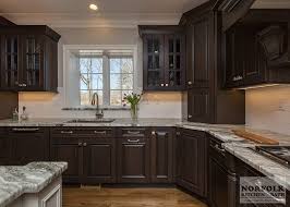 Timeless dark cherry kitchen cabinets accented with aged elements, like seeded glass and oil rubbed bronze hardware, keep a keeping a balance between old and new in a retrofitted space doesn't have to be tricky. Greywash Cherry Custom Kitchen With White Island